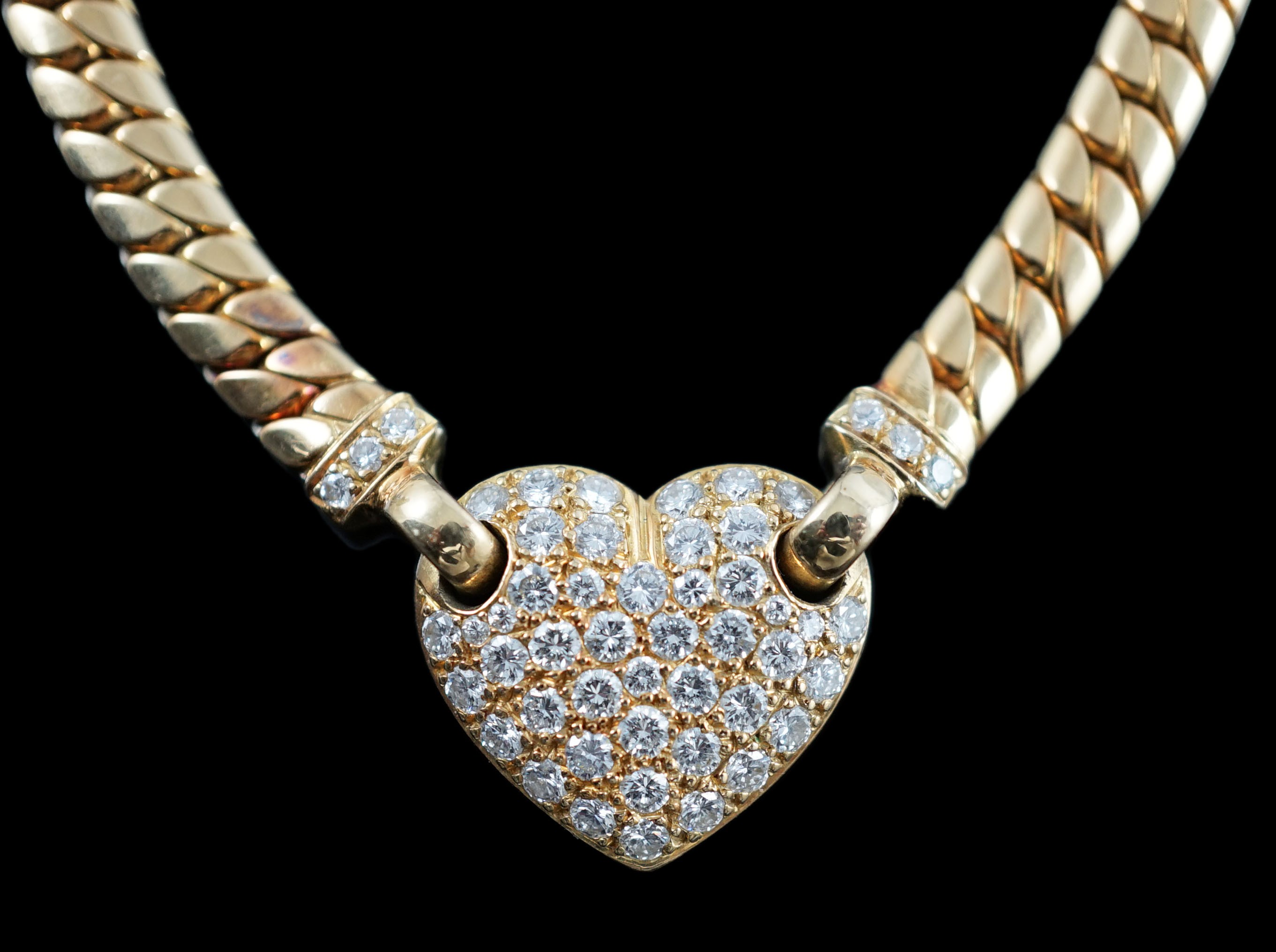 A modern 18ct gold and pave set diamond heart shaped pendant necklace